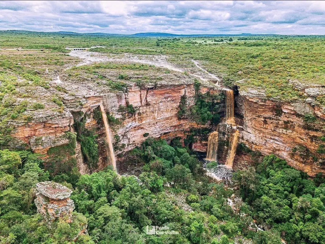 Aerial view of a horseshoe canyon with three waterfalls dropping from the plateau