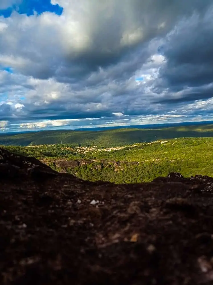 View from the lookout: green plateau to the horizon under heavy clouds